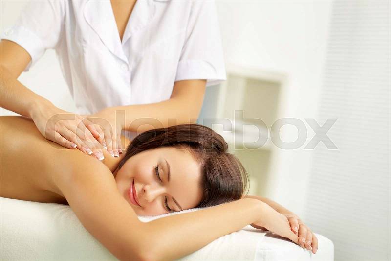 Young woman enjoying spinal massage, stock photo