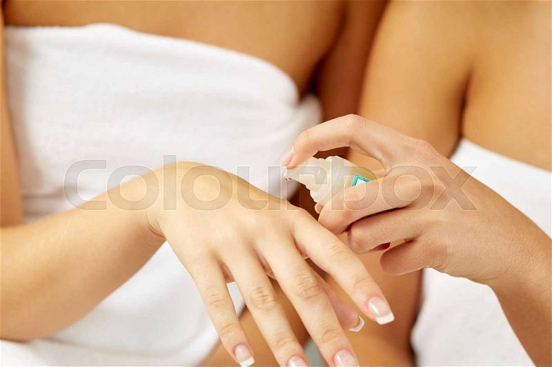 Closeup of female hand applying hand oil, stock photo
