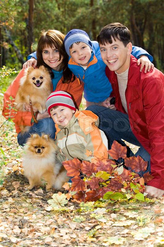 Portrait of happy family with two dogs in the forest, stock photo