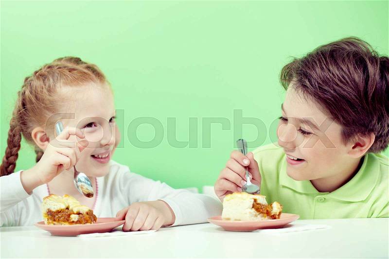 Two little children eating pie, stock photo