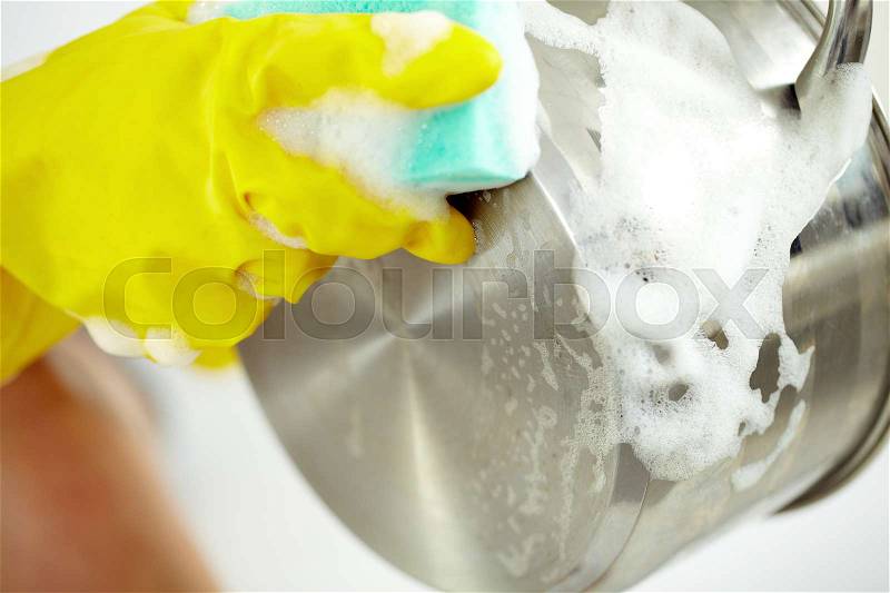 Close-up of hands in gloves washing a saucepan, stock photo