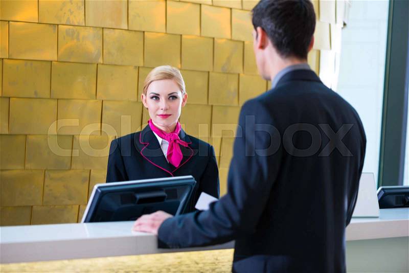 Man in Hotel check in at reception or front office being given key card, stock photo