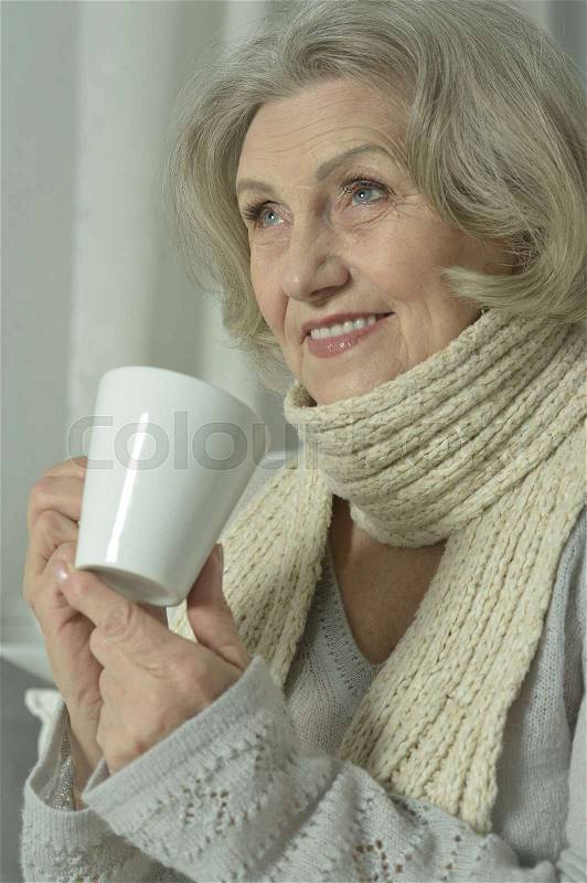 Sick senior woman with cup of tea at home, stock photo