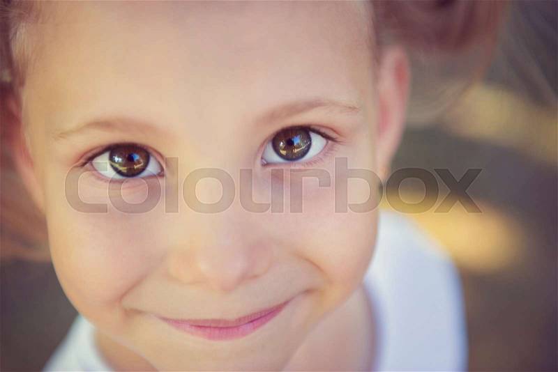 Excited face of pretty small girl in summer park, stock photo