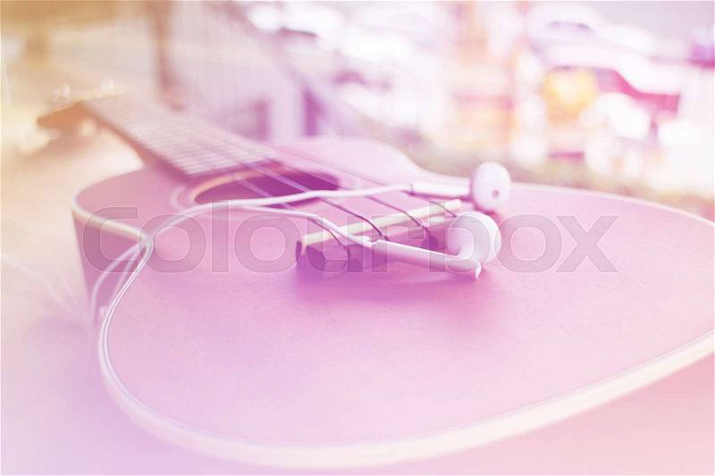 Soft and blurred of Ukulele and earphone vintagr tone for background, stock photo
