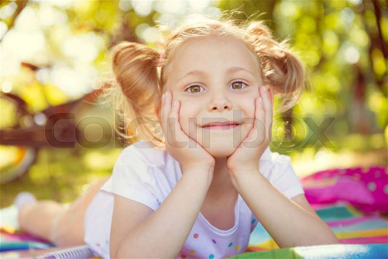 Excited face of pretty small girl in summer park, stock photo