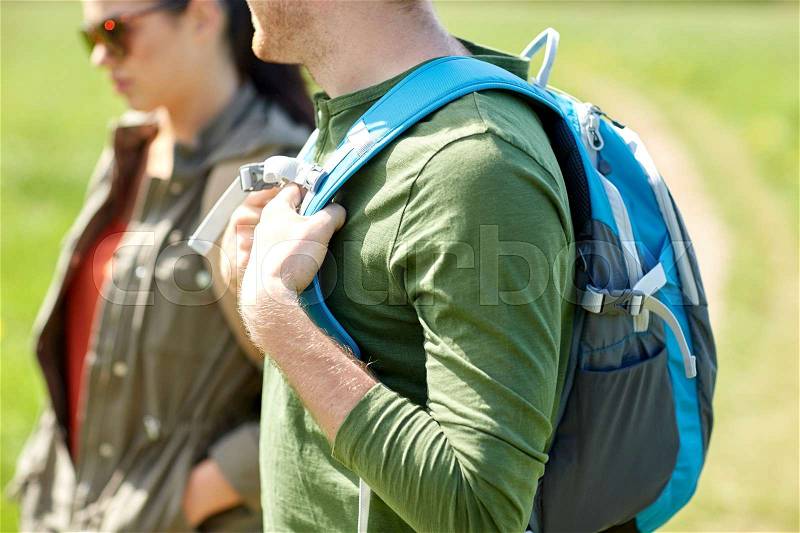 Travel, hiking, backpacking, tourism and people concept - close up of couple with backpacks walking outdoors, stock photo