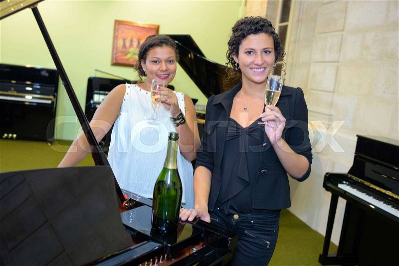 Drinking champagne in a piano store, stock photo