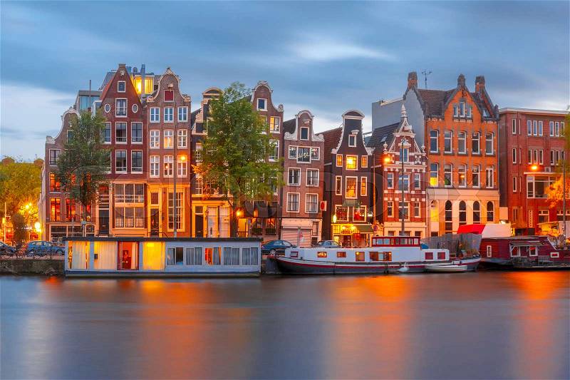 Amsterdam canal Amstel with typical dutch houses and boats during twilight blue hour, Holland, Netherlands, stock photo