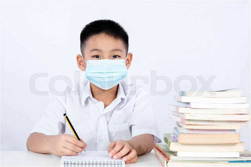 Asian Chinese Student Boy Writing with Protection Mask in plain isolated white background, stock photo