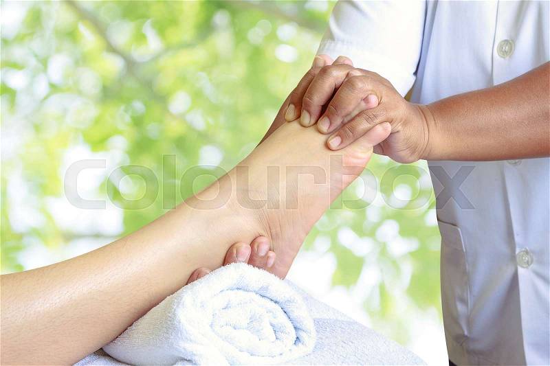 Masseur doing reflexology,Thai foot massage in spa on nature background, stock photo