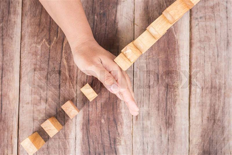 Close up hand stop wooden block. Domino risk effect concept, stock photo