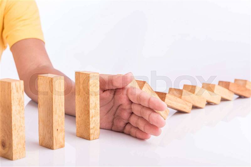 Close up hand stop wooden block. Domino risk effect concept, stock photo
