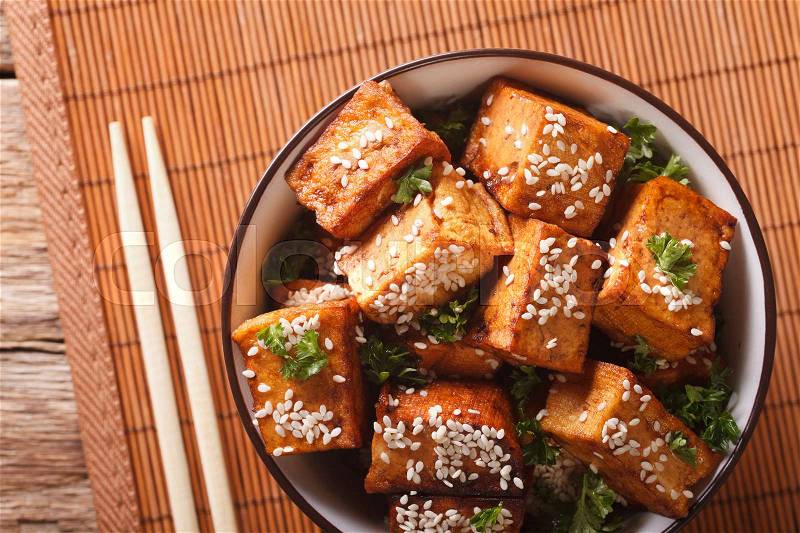 Stir fry tofu with sesame seeds and herbs in a bowl close-up. horizontal view from above , stock photo