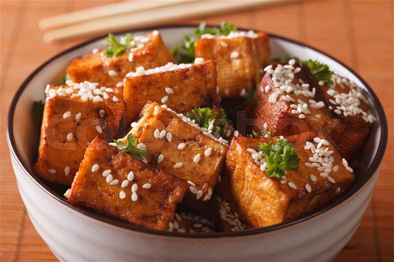 Stir fry tofu with sesame seeds and herbs in a bowl close-up. horizontal , stock photo