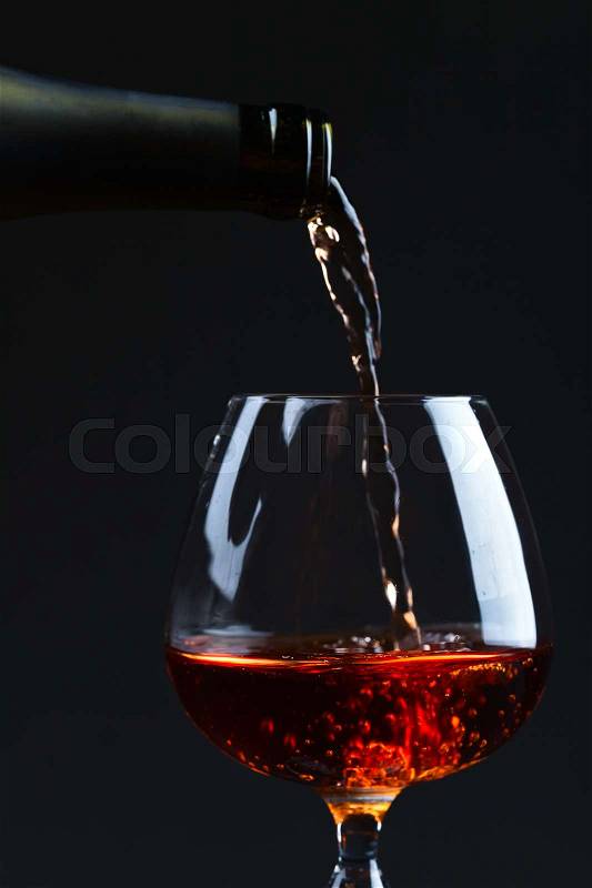 Snifter with brandy on a black background, stock photo
