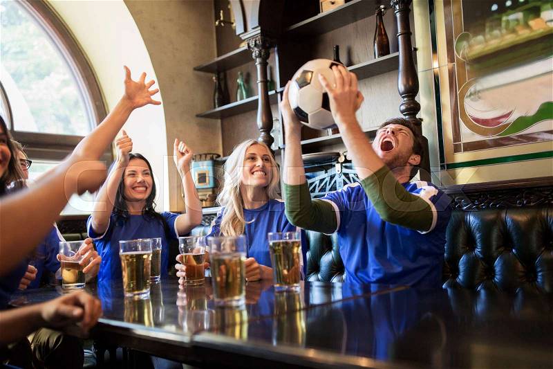 Sport, people, leisure, friendship and entertainment concept - happy football fans or friends drinking beer and celebrating victory at bar or pub, stock photo