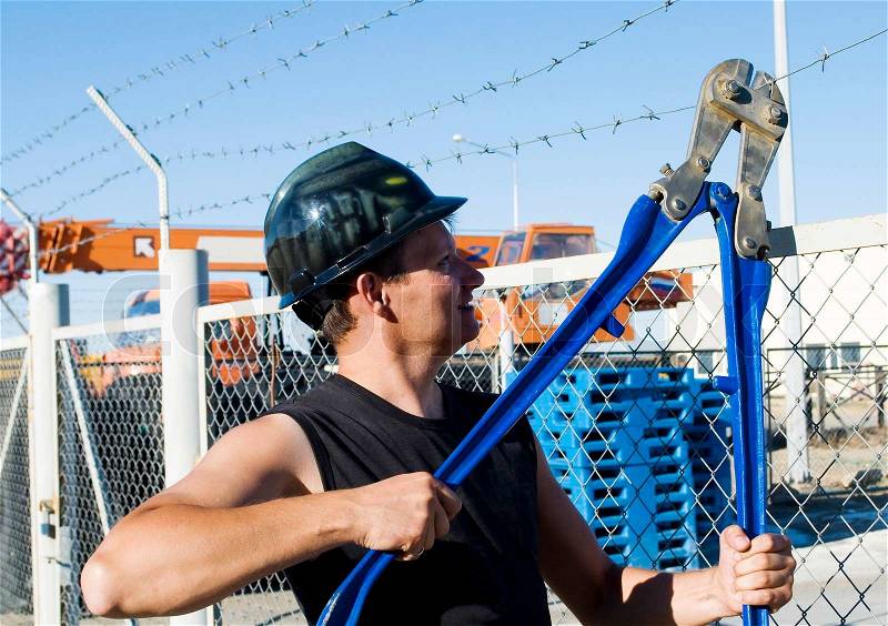 Worker cuts the barbed wire, stock photo