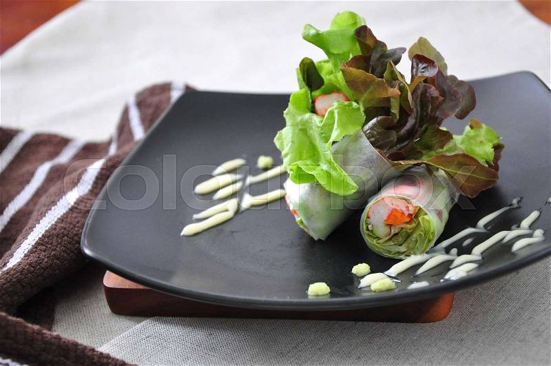 Close up veggie and crab stick roll on black plate, stock photo