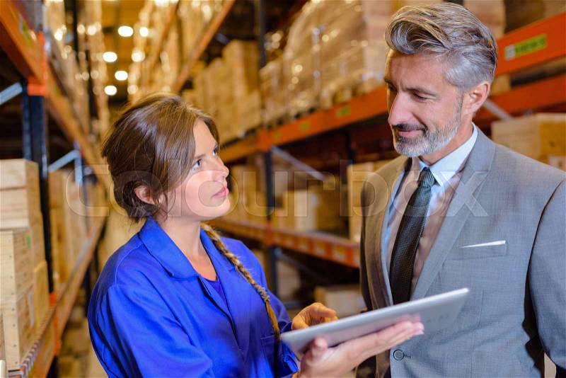 Boss and employee in warehouse, stock photo