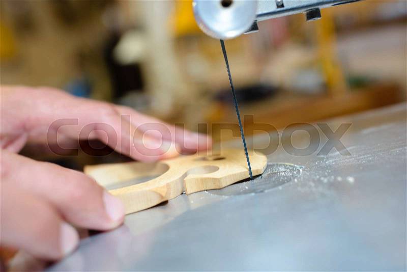 Closeup of blade cutting out guitar bridge, stock photo