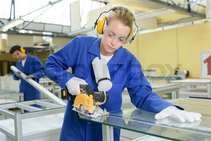 Woman cutting through glass with rotary blade, stock photo