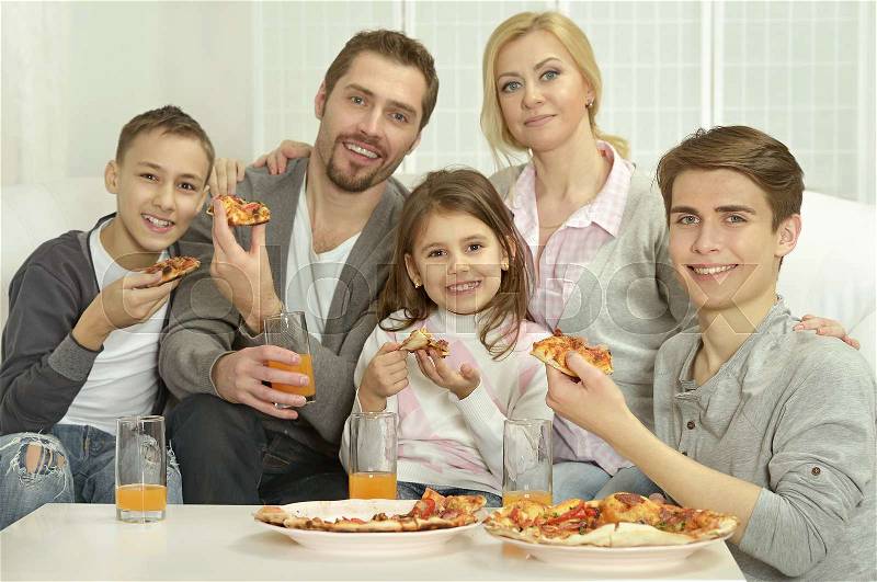 Portrait of happy family at home with pizza, stock photo