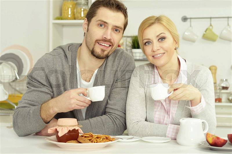 Smiling couple at table with coffee and food, stock photo