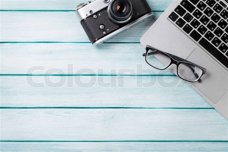 Desk table with laptop and camera on wooden table. Workplace. Top view with copy space, stock photo