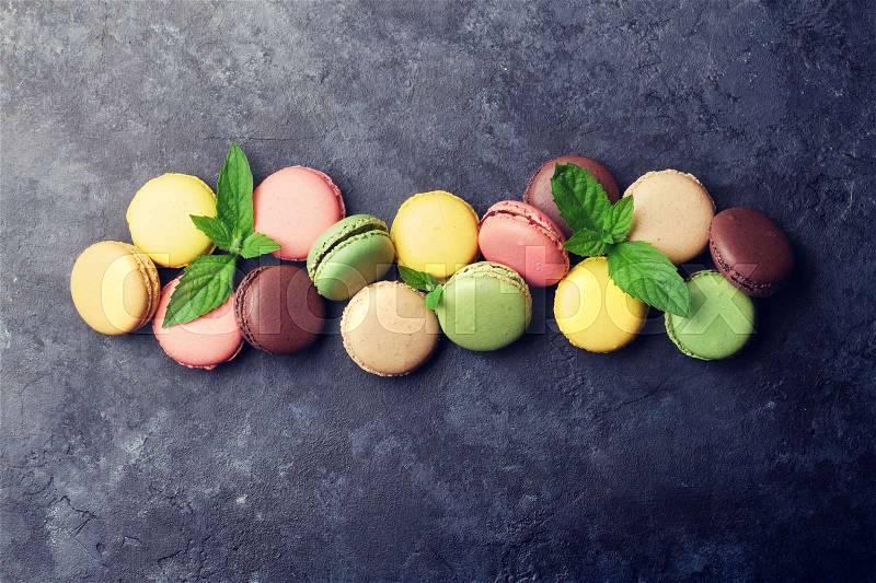 Colorful macaroons on stone table. Sweet macarons. Top view with copy space for your text, stock photo