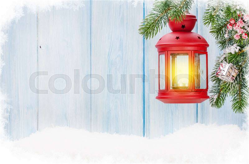 Christmas candle lantern on fir tree branch in snow. View with copy space, stock photo