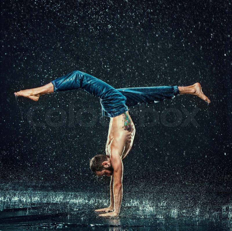 The male break dancer in water on dark background, stock photo