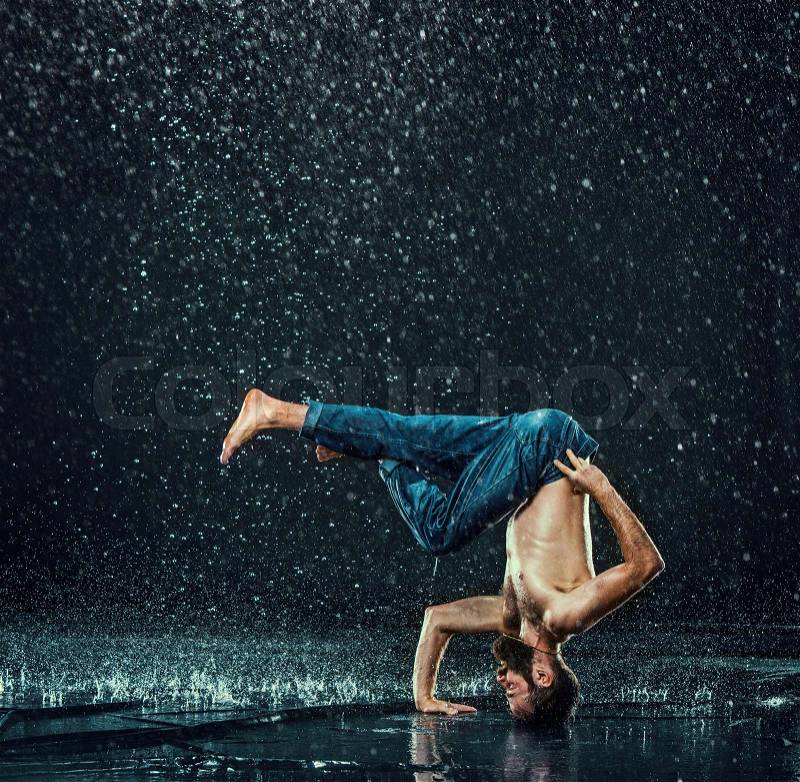 The male break dancer in water on dark background, stock photo