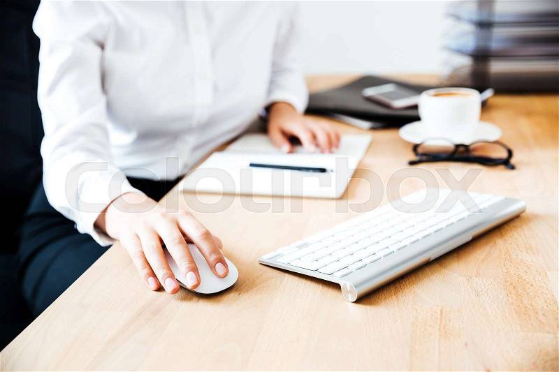 Cropped image of women\'s hands using keyboard and mouse at the office, stock photo