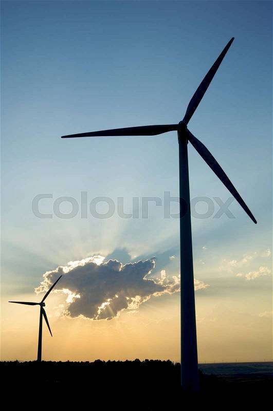 Two windmills against cloudy sky at sunset in Tardienta, Huesca, Aragon, Spain, stock photo
