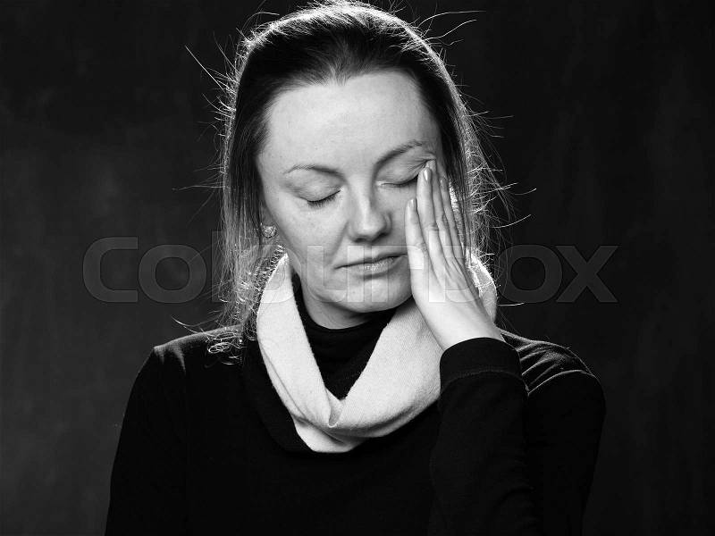 Close up sad woman wiping the tears away, black and white, stock photo