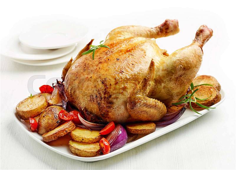 Whole roasted chicken on white plate, stock photo