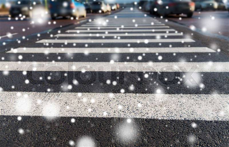 Safety, traffic laws, highway code and road sign concept - close up of pedestrian crosswalk on city car parking over snow, stock photo