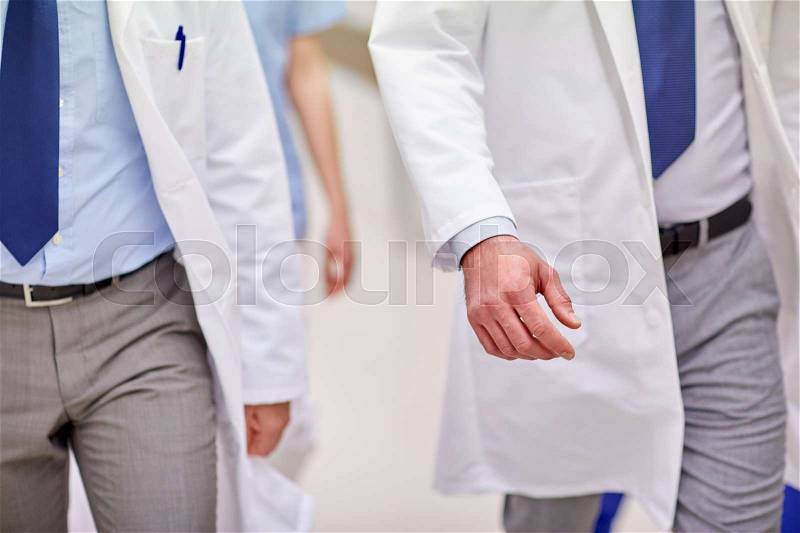 Clinic, profession, people, healthcare and medicine concept - close up of medics or doctors walking along hospital, stock photo