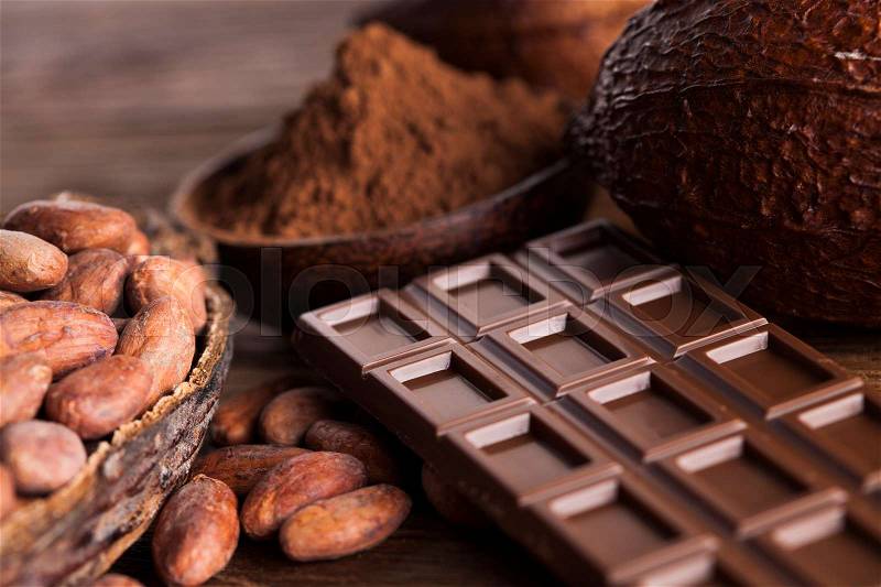 Chocolate bar, candy sweet, cacao beans and powder on wooden background, stock photo
