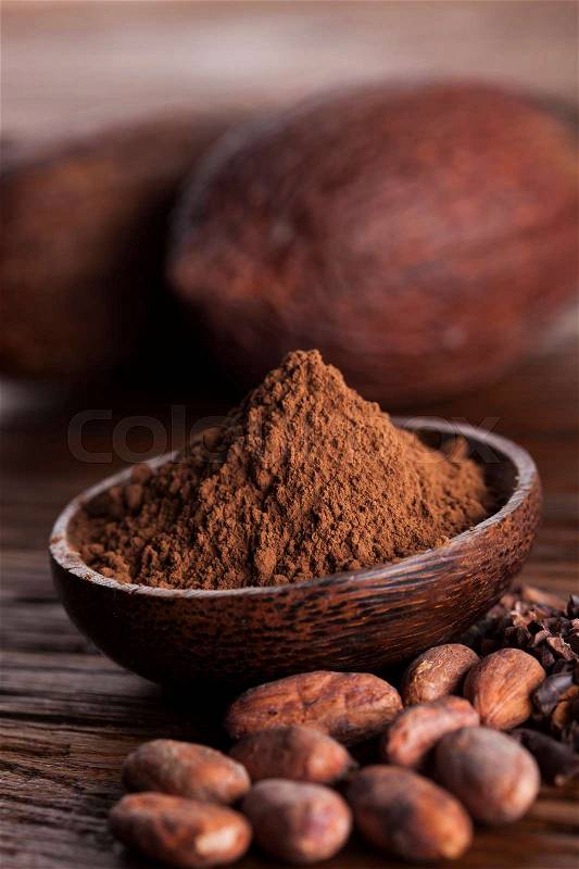 Cocoa beans in the dry cocoa pod fruit on wooden background, stock photo