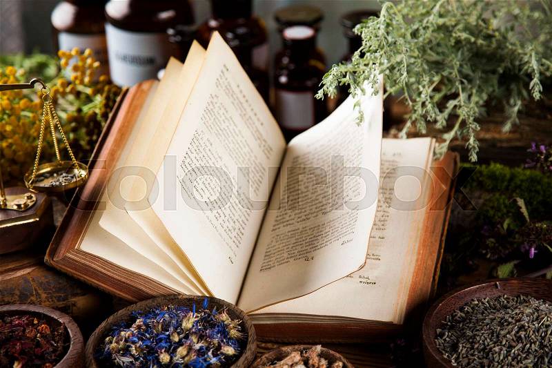 Herbal medicine and book on wooden table background, stock photo