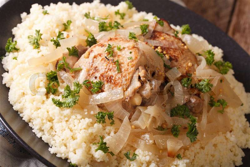 Traditional African food: poulet Yassa with onion and couscous macro on the table. horizontal , stock photo