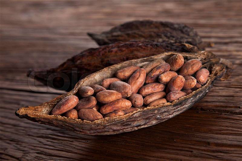 Cocoa pod on wooden background, stock photo