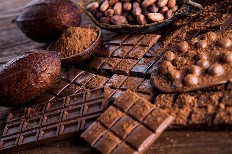Dark homemade chocolate bars and cocoa pod on wooden, stock photo