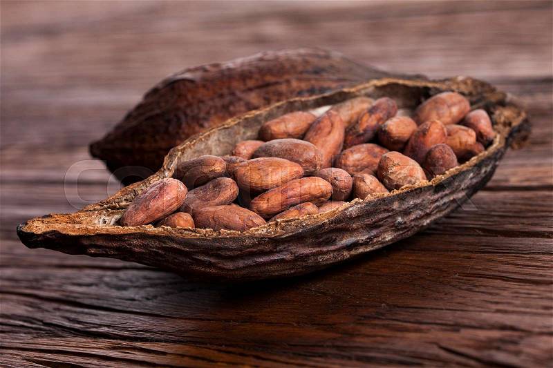 Cocoa pod on wooden background, stock photo