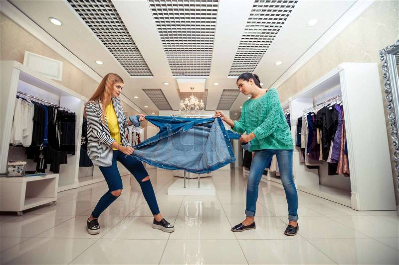 Young women fighting for a jacket in the shop, stock photo