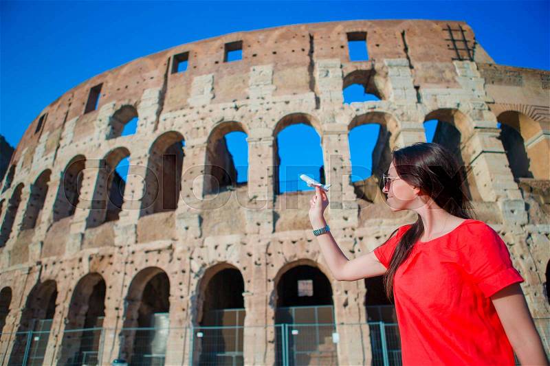 Young beautiful woman with small toy model airplane background Colosseum in Rome, Italy, stock photo