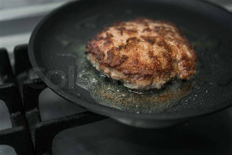Big and juicy burger cutlet on metal pan, stock photo