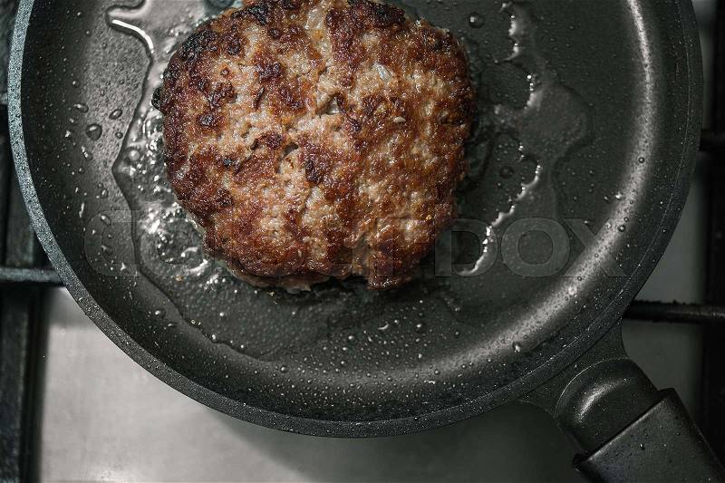 Big and juicy burger cutlet on metal pan, stock photo